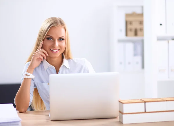 Attraente donna d'affari seduta su una scrivania con computer portatile in ufficio — Foto Stock