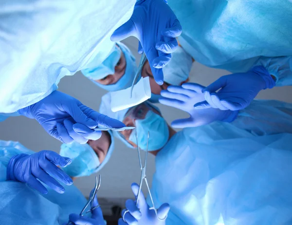 Cirurgiões segurando instrumentos médicos nas mãos e olhando para o paciente — Fotografia de Stock