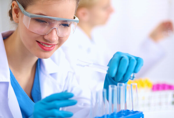 Woman researcher is surrounded by medical vials and flasks, isolated on white background