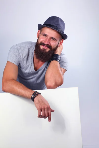 Retrato de jovem de chapéu em pé perto de branco, isolado sobre fundo branco — Fotografia de Stock