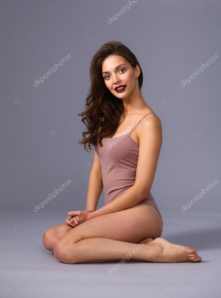 Beautiful barefoot woman sitting on the floor — Stock Photo