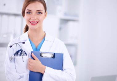 Hastanede üniformalı, gülümseyen bir kadın doktor.