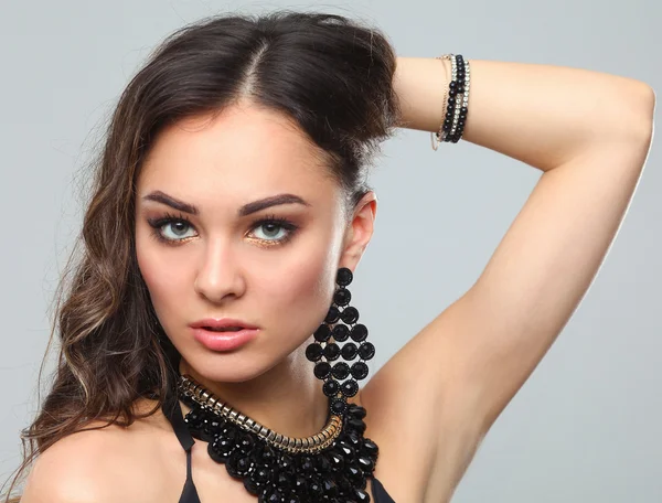 Portrait of a beautiful woman with necklace, isolated on gray background — Stock Photo, Image