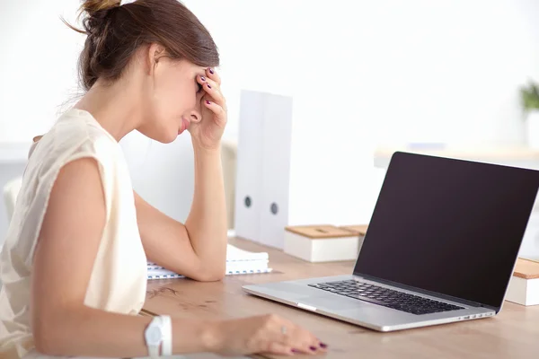 Retrato de una joven mujer de negocios cansada con computadora portátil en la oficina —  Fotos de Stock