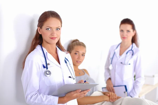 Médecin souriante avec un dossier en uniforme debout à l'hôpital — Photo