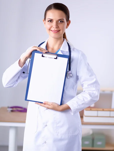 Médico sonriente con una carpeta en uniforme de pie — Foto de Stock