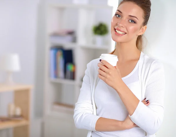 Attractive young businesswoman standing  near wall in office — Stock Photo, Image