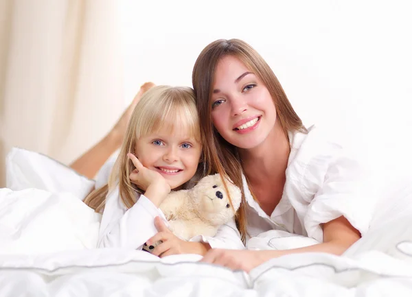 躺在床上微笑的女人和年轻女孩 — 图库照片