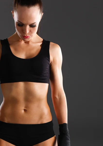 Musculosa joven de pie sobre fondo gris — Foto de Stock