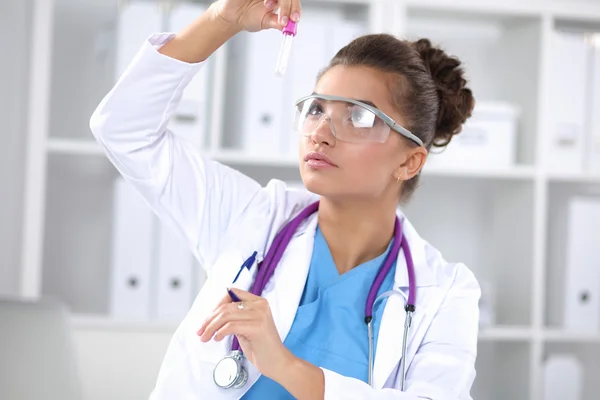 Woman researcher is surrounded by medical vials and flasks — Stock Photo, Image