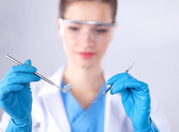 Attractive female dentist with tools , standing on gay background Stock Photo