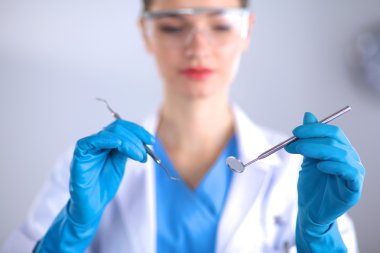 Gri üzerine ayakta araçlarıyla çekici kadın diş hekimi