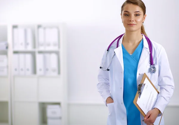 Médico sonriente con una carpeta en uniforme de pie — Foto de Stock