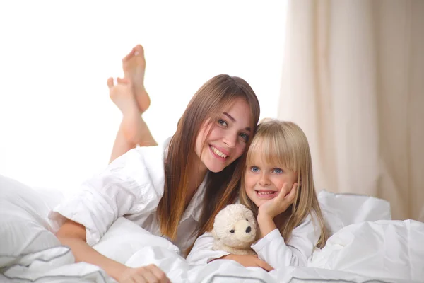 Femme et jeune fille couchée au lit souriant — Photo