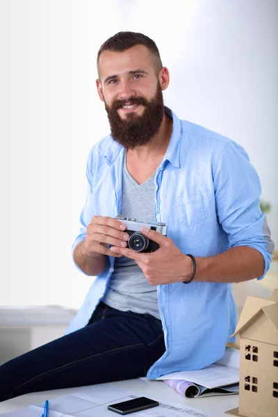 Retrato del diseñador masculino sentado en una mesa con planos — Foto de Stock