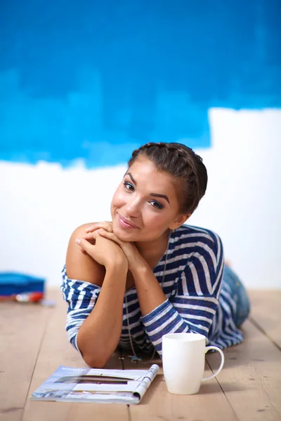 Portrait of female painter sitting on floor after painting — Stock Photo, Image