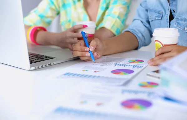 Due donne che lavorano insieme in ufficio, sedute sulla scrivania — Foto Stock