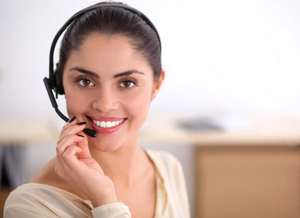 Portret van een mooie zakenvrouw werkend aan haar bureau met headset en laptop — Stockfoto