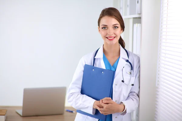 Woman doctor is standing near window with crossed arms,isolated — Stock Photo, Image