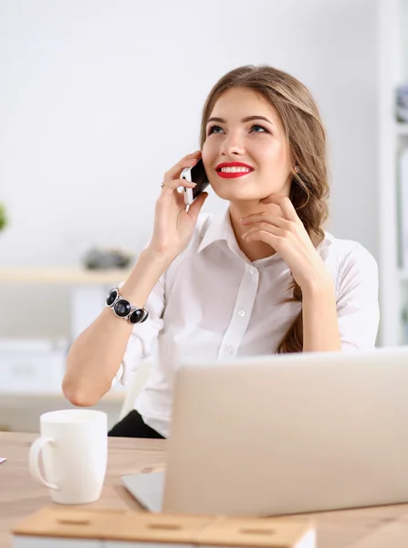 Молодая деловая женщина сидит и разговаривает по телефону — стоковое фото