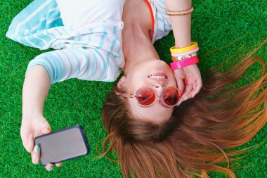 güzel ve genç birbayan yeşil çim yalan onu telefonla selfie yapma