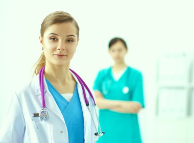 Kadın doktor hastanede steteskopla dikiliyor.