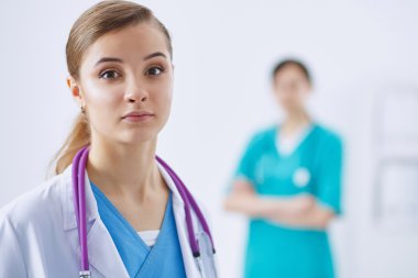 Kadın doktor hastanede steteskopla dikiliyor.