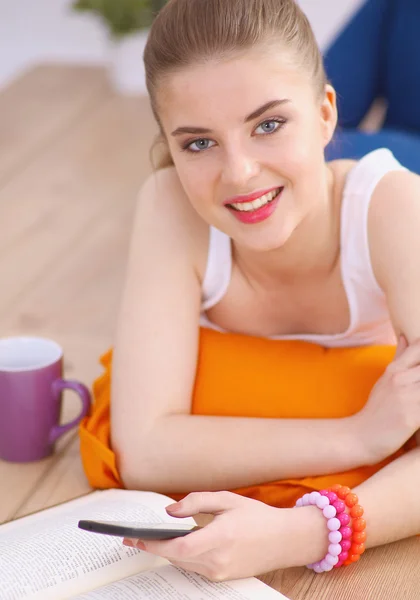 Usměvavá mladá žena ležící na podlaze, bílé s polštářem — Stock fotografie