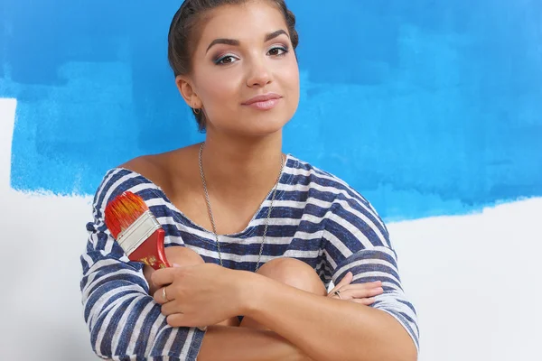 Portrait of female painter sitting on floor near wall after painting. — Stock Photo, Image