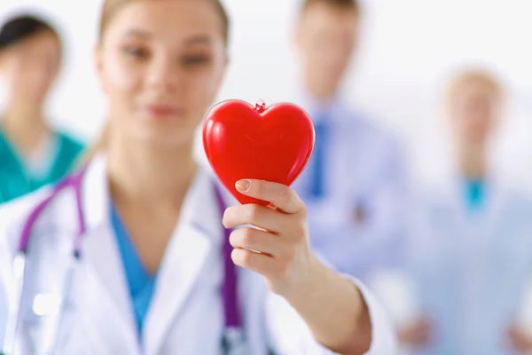 Female doctor with stethoscope holding heart — Stock Photo, Image