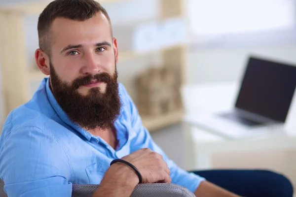 Jonge man zittend met laptop en een kopje thee thuis — Stockfoto