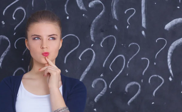 Young girl with question mark on a gray background — Stock Photo, Image