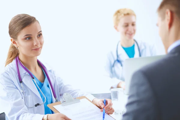 Ärzteteam sitzt in modernem Krankenhaus am Tisch — Stockfoto