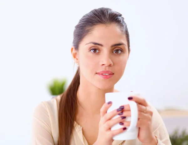 Vacker affärskvinna njuter av kaffe i ljusa kontor — Stockfoto