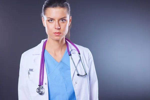 Mujer doctora joven con estetoscopio aislado en gris —  Fotos de Stock