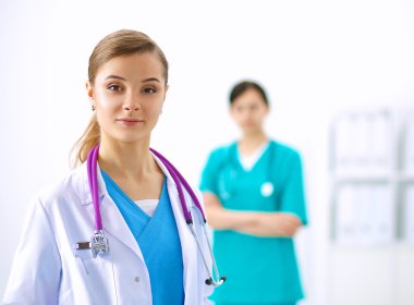 Kadın doktor hastanede steteskopla dikiliyor.