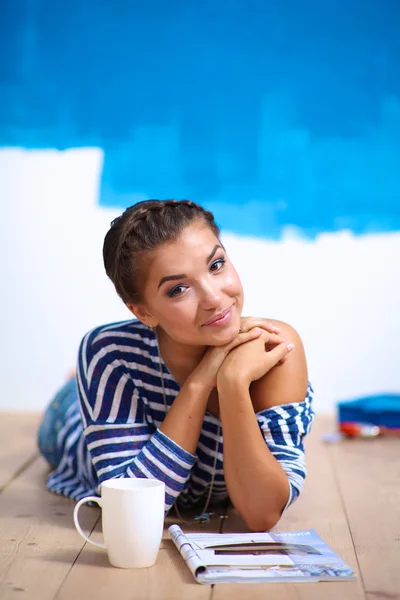 Portret van vrouwelijke schilder zittend op de vloer na schilderij — Stockfoto