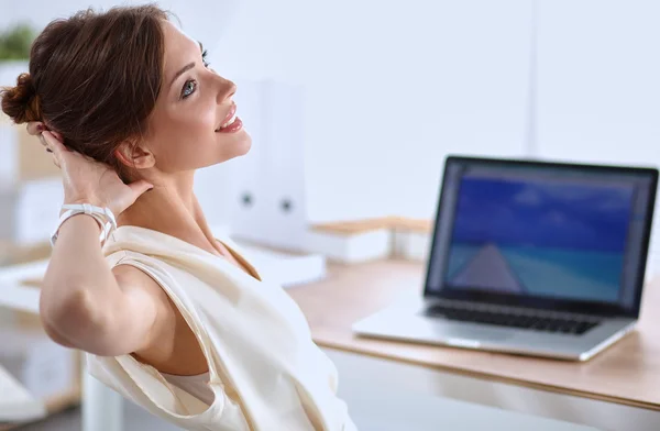 Mujer de negocios relajándose con las manos detrás de la cabeza y sentada en una silla de oficina — Foto de Stock