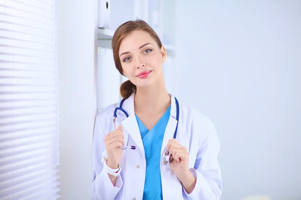 Woman doctor is standing near window with crossed arms,isolated — Stock Photo, Image