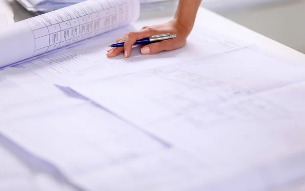 Portrait of female architect with blueprints at desk in office, isolated — Stock Photo, Image