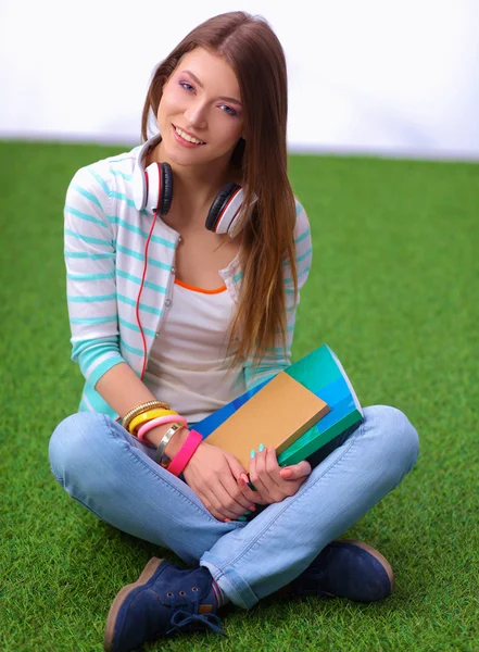Женщина читает книгу сидит на зеленой траве — стоковое фото