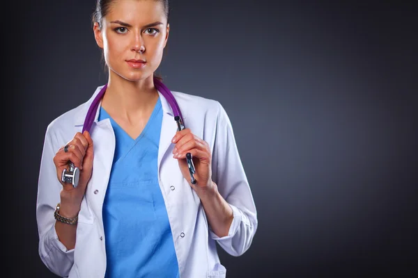 Retrato de una joven doctora sosteniendo un estetoscopio, aislada sobre fondo negro — Foto de Stock