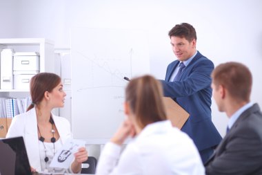 İş adamları iş toplantısında, ofiste oturup tartışıyorlar.