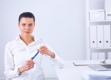 Ofiste dizüstü bilgisayarı olan çekici bir iş kadını.