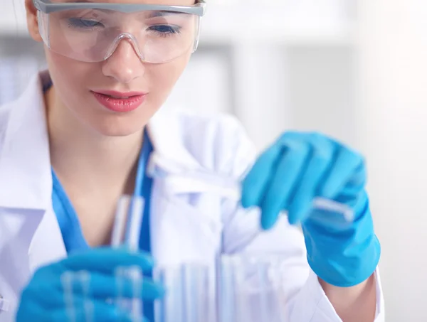 Woman researcher is surrounded by medical vials and flasks, isolated on white background — Stock Photo, Image