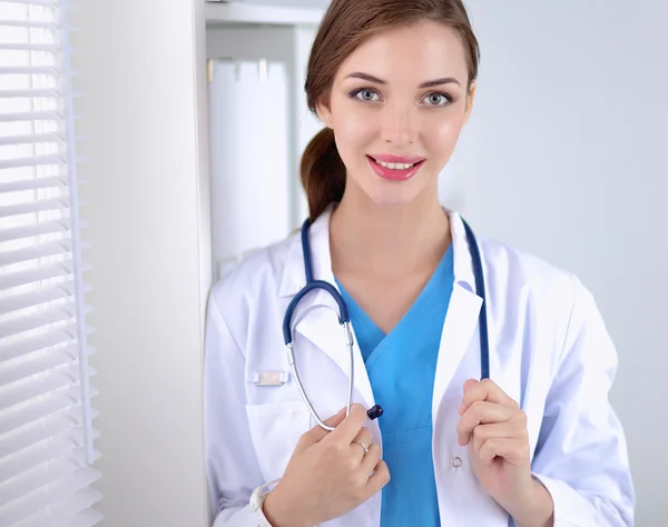 Woman doctor is standing near window with crossed arms,isolated — Stock Photo, Image