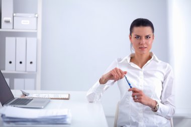 Ofiste dizüstü bilgisayarı olan çekici bir iş kadını.