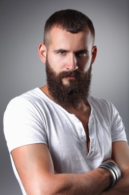 ayakta, gri arka plan üzerinde izole yakışıklı sakallı adam portresi