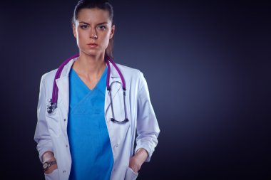 Steteskoplu genç doktor kadın gri arka planda izole edilmiş.