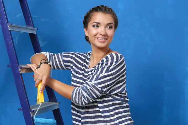 Portrait of female painter sitting on floor near wall after painting. — Stock Photo, Image